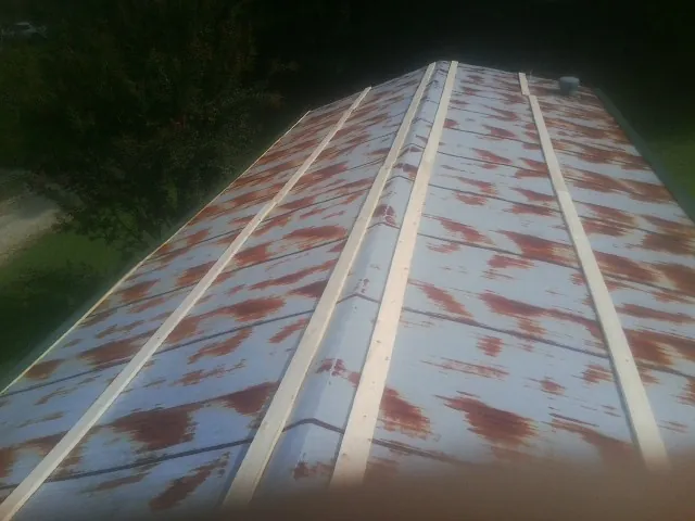 Rusted metal roof panels with new wood purlins before replacement — Storm Damage Roof Repair in Swanlake by Roofing Brothers
