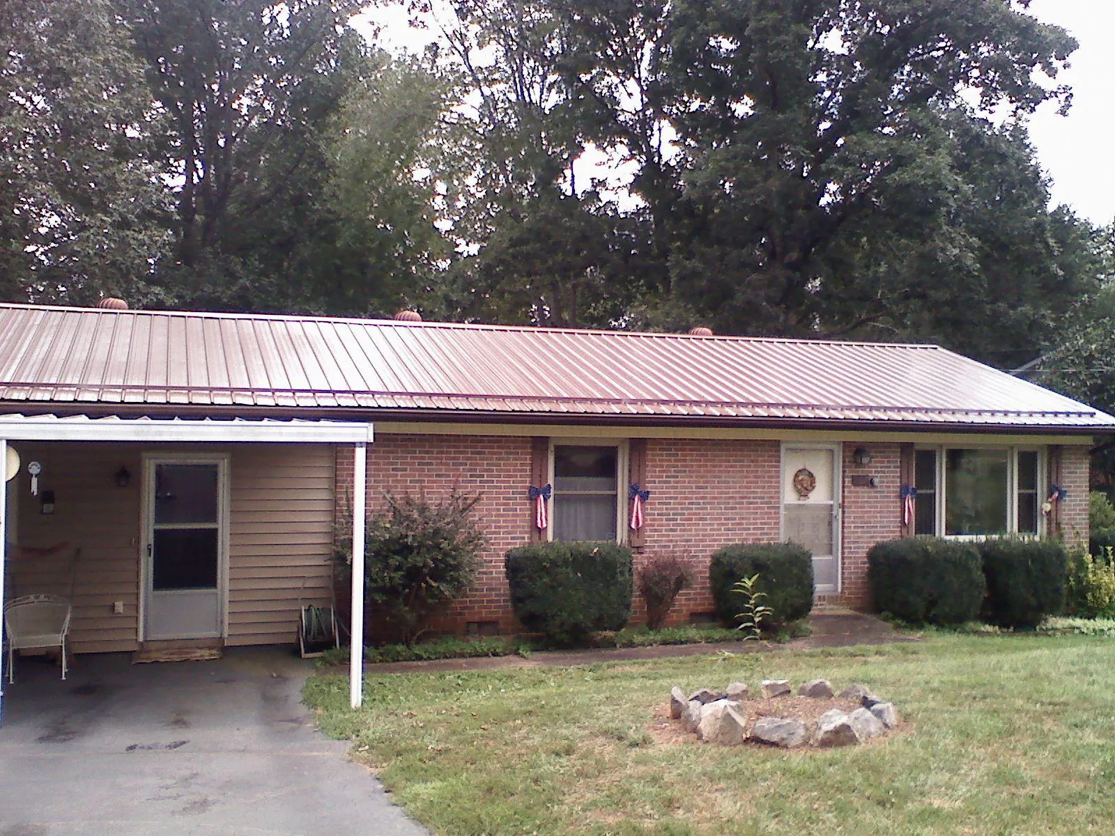 Bronze metal roof and carport on a brick ranch home — Roof Repair work by our crew in Swanlake